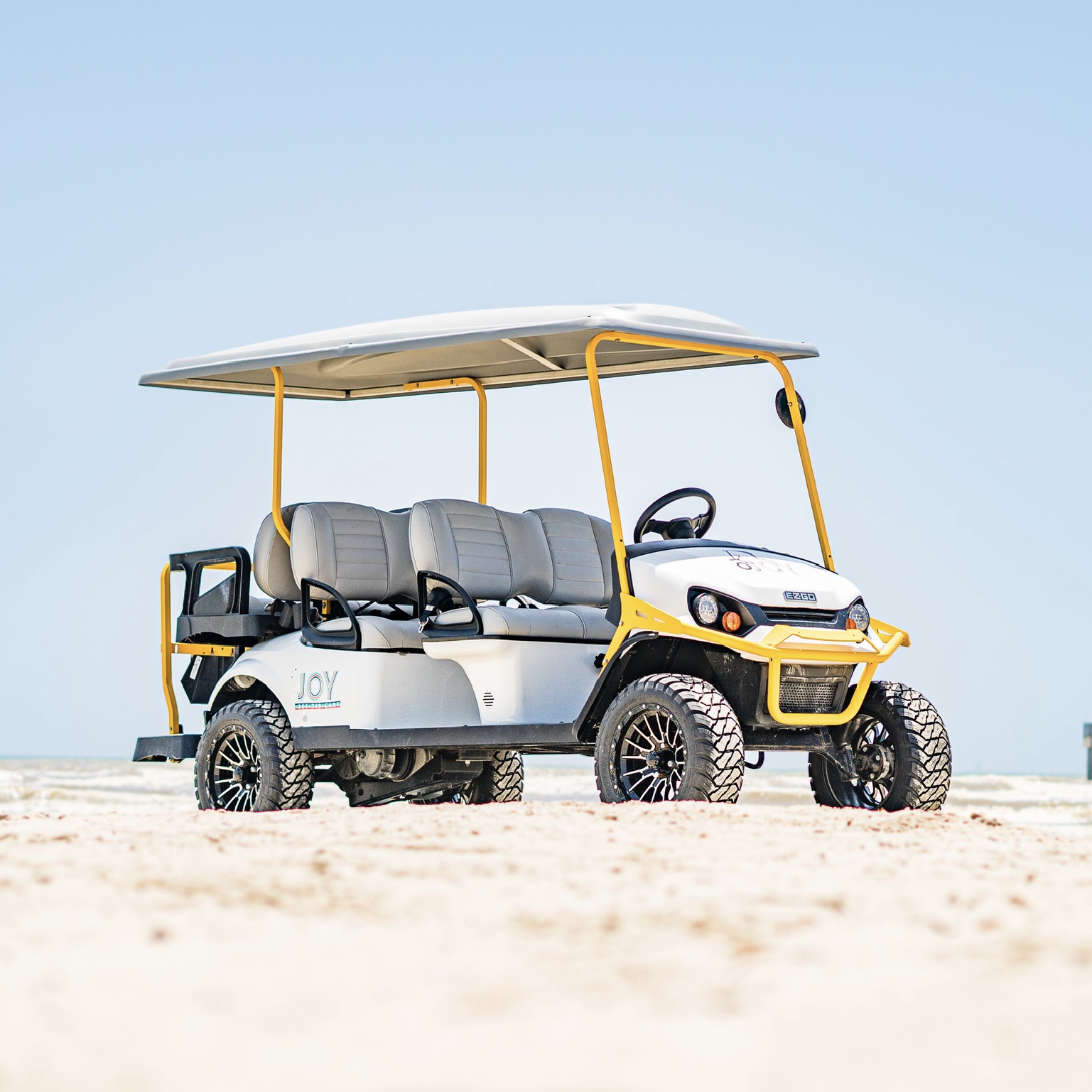 Six passenger E-Z-GO golf cart with yellow safety bars on Port Aransas beach