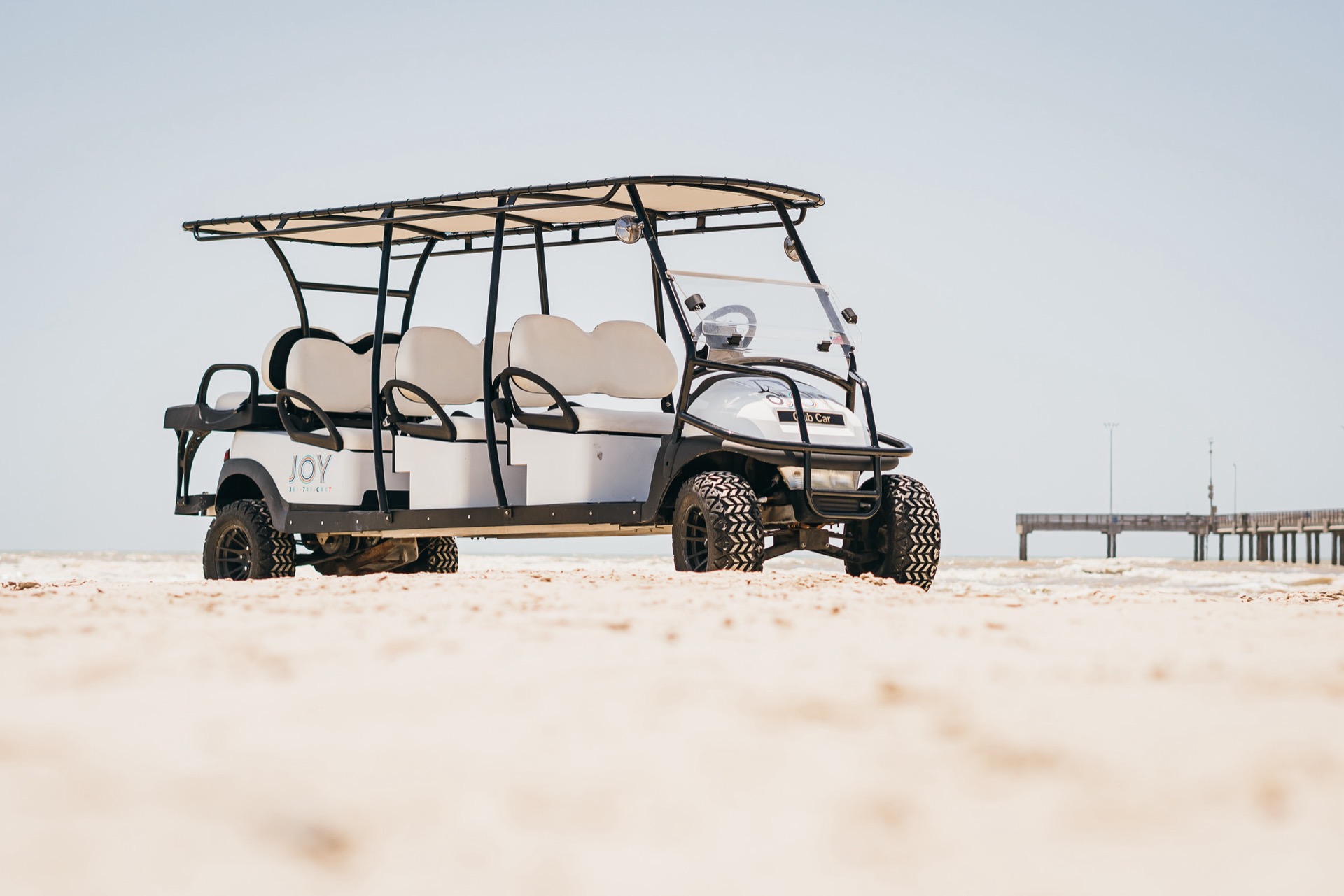 Eight-passenger Club Car stretch on the beach with the Gulf in the background